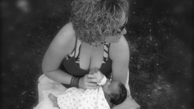 Kristen Day, a single mom with curly hair, feeding her baby with a bottle in black and white