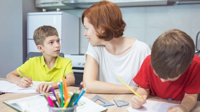 Mom helping her kids with the homework while listening to all the "Why" questions