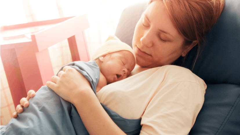 A newborn baby sleeping on its mother's breasts