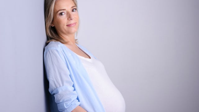 pregnant woman leaning against wall