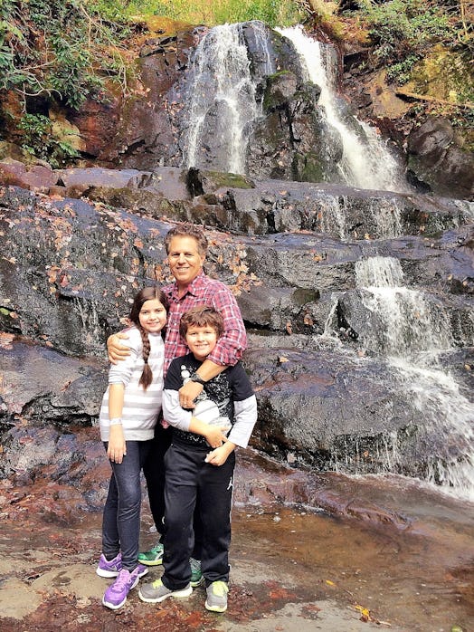 Lindsey Ferries' husband and their two children standing in front of the 'Laurel Falls Trail'