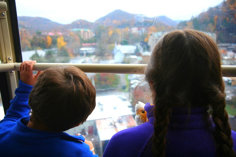 A boy and a girl in blue shirts on the Aerial Tram going to Ober Gatlingburg watching the scenery