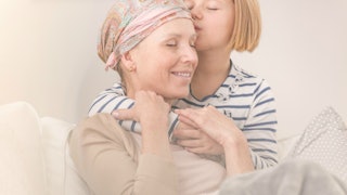 A daughter hugging her mother who is suffering from cancer.