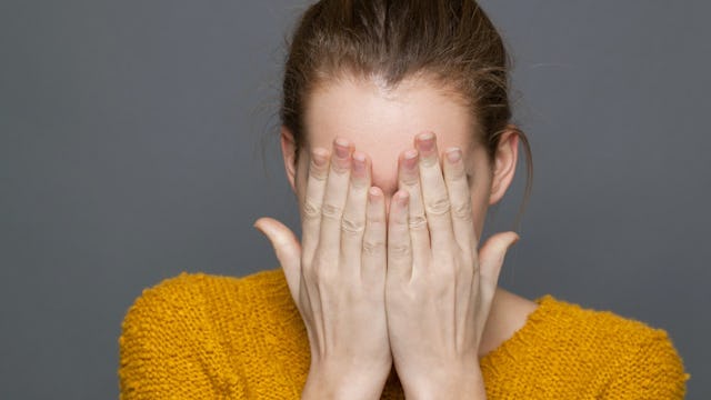 A mom with social anxiety covering her face with hands