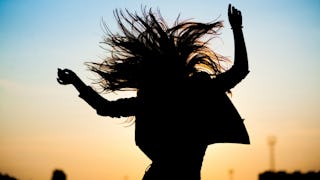 A woman jumping happily who is considered to be a 'weird' girl who doesn't quite fit in