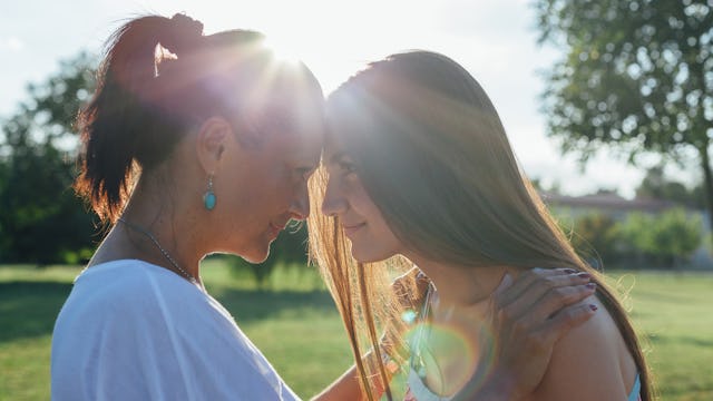 Mother and daughter with their foreheads pressed together while the mother is refusing to tell her k...