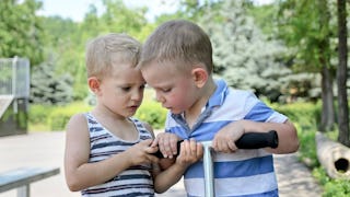 Two boys fighting fighting for a scoter as one boy has been taught that he doesn't have to share