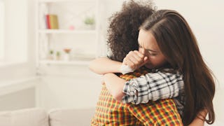 A girl comforting her friend struggling with mental health issues