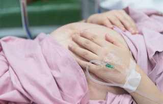 A pregnant woman in a hospital bed before experiencing a blood clot