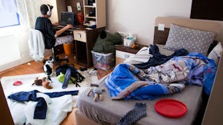 A kid playing video games in his messy room