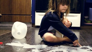 A little girl playing on the floor making a mess which parents shouldn't apologize for