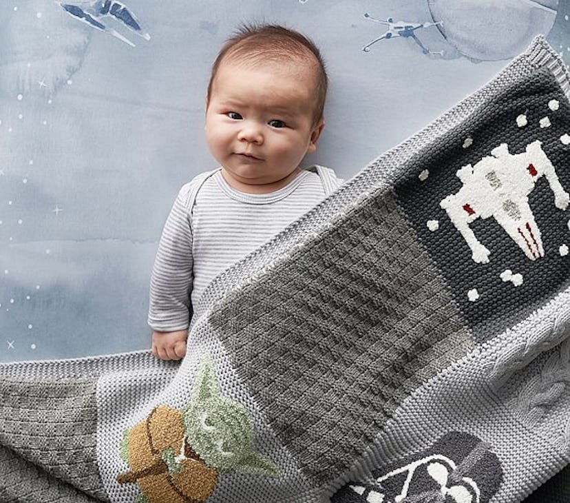 Items From The Star Wars Pottery Barn Collection: baby covered with Star Wars inspired blanket.