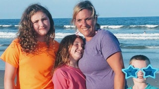 Suzanne Hayes with her two daughters and her son standing and posing at a beach