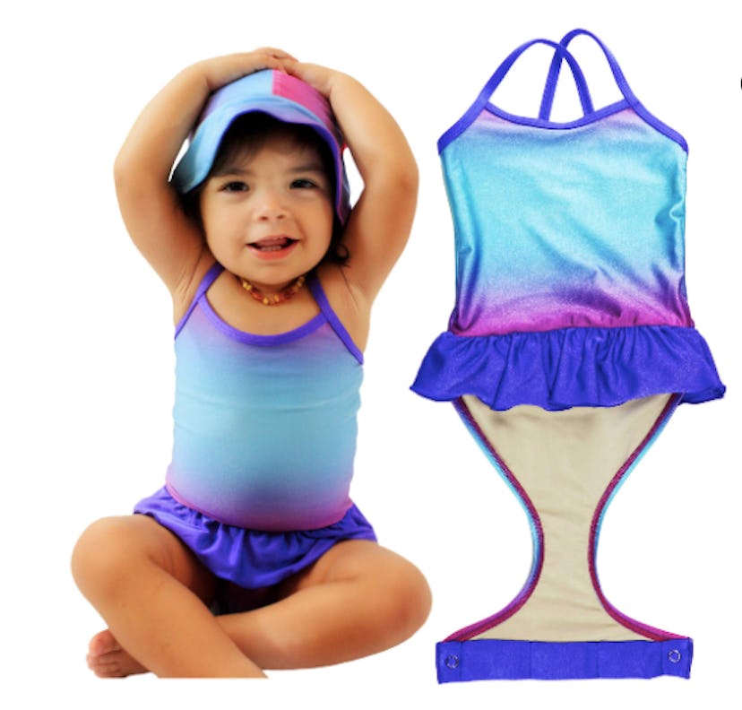 A baby girl sitting in the Fasten's blue one-piece bathing suit.