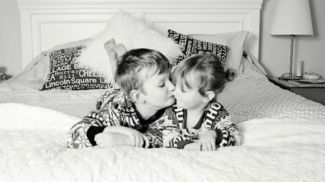 An older brother kissing his sister