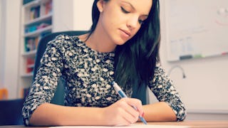 A woman filling out a paper during the college application season while sitting