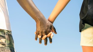 A black man and white woman holding hands
