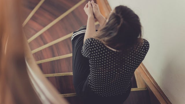 Bird's Eye View Of A Lonely Woman Siting On A Spiral Staircase