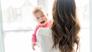 A mother holding her crying baby 