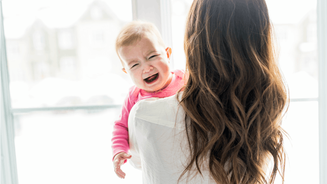 A mother holding her crying baby