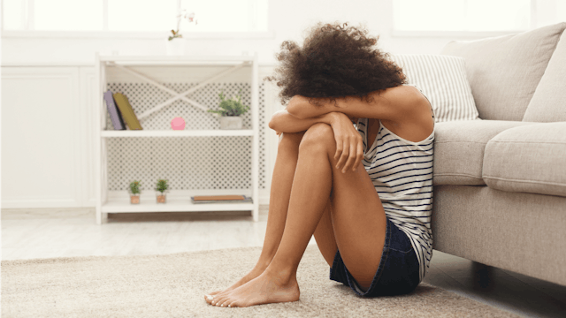 A depressed woman crying on the floor