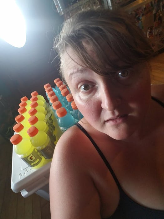 Kira Gilbertson taking a selfie next to a table with several juice bottles placed on it