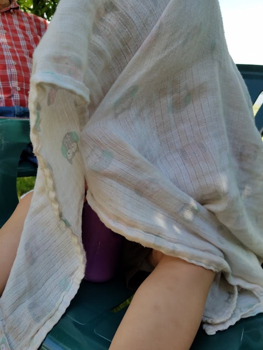 Kira Gilbertson sitting with a scarf covering her head during camping