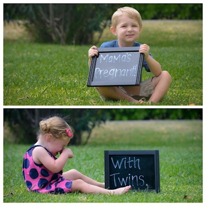 A boy and a girl sitting on the grass with signs next to them of "Mama's pregnant" and "With twins,"...