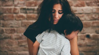 A distraught mother holding her child because there is a hidden danger for them in family court