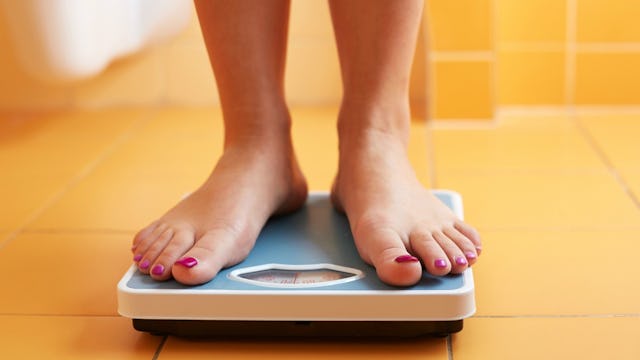 A woman considering IVF standing on a scale