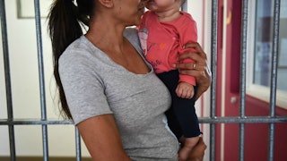 A mom in prison holding her baby behind bars
