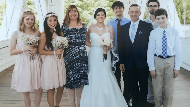 Six family members taking a photo with bride and groom at their wedding