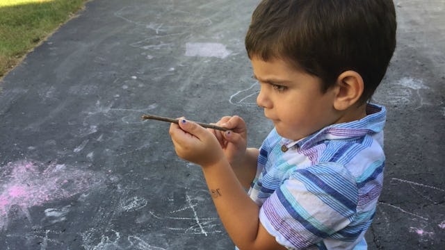 A boy playing with a stick as it is a gun