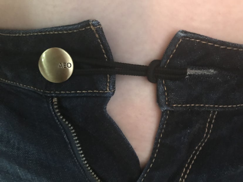 A hairband keeping the pants together over the button
