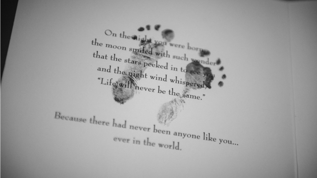 A poem written on paper with baby footprints over it