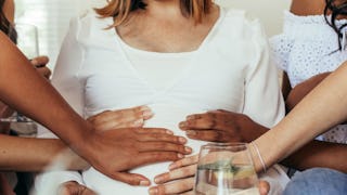 Pregnant woman surrounded by her friends at the baby shower