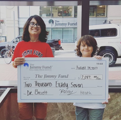 Two brother holding a $2087 check for the Jimmy Fund 