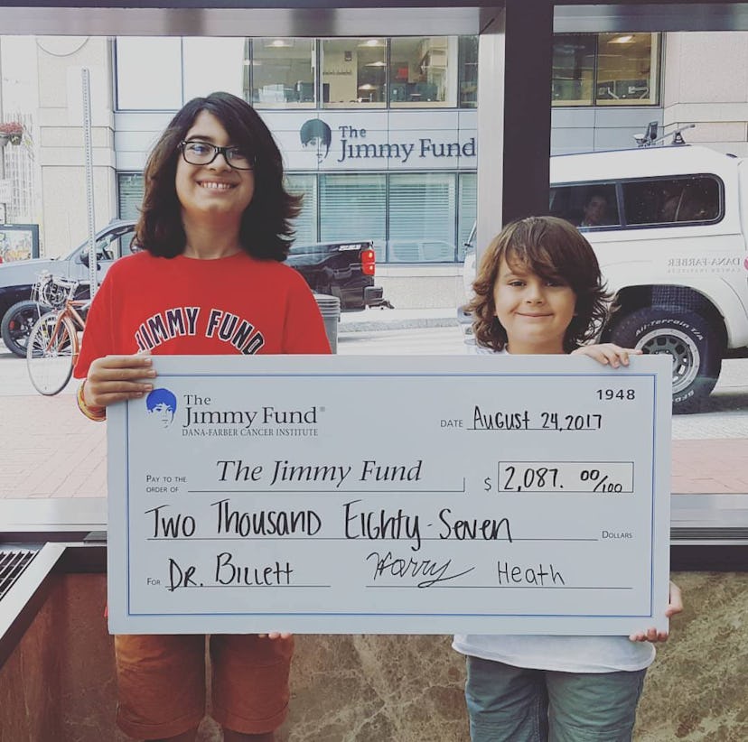 Two brother holding a $2087 check for the Jimmy Fund 