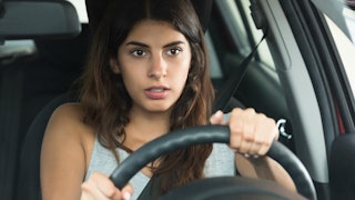 A woman sitting behind the steering wheel in the car feeling the anxiety in that moment