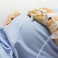 Pregnant woman suffering from Hyperemesis Gravidarum and holding her stomach with medical devices st...