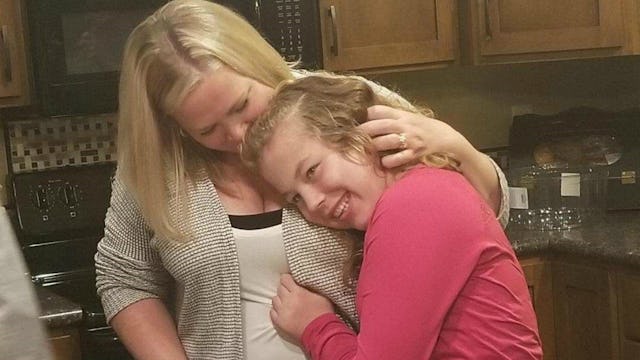 Abby Kopf hugging her special needs daughter in the kitchen.