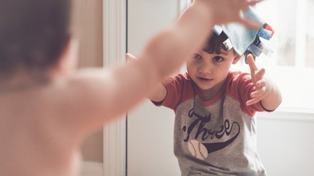 A toddler and a little boy going in for a hug