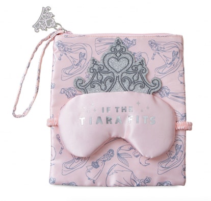 A pale pink satin sleep mask with the writing 'If the tiara fits' on pale-pink printed pouch for it