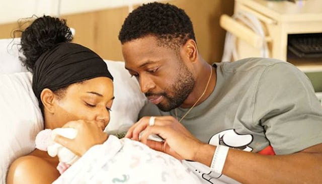 Gabrielle Union and her husband holding their newborn baby in the hospital
