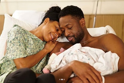 Gabrielle Union and her husband laying in bed in the hospital and holding their baby 
