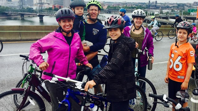 A mother, a father and their four children on bikes smiling and posing