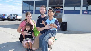 A blind mother with her husband and blind kids posing together at a parking lot