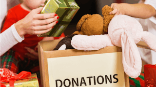 A carton box filled with toys and text "Donations" on it