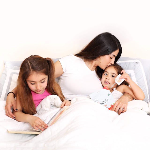 Mom and two kids snuggling in bed