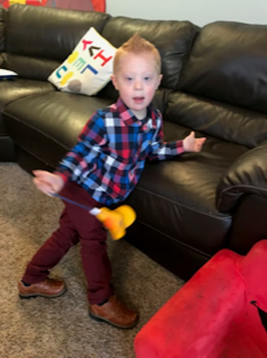 Bethann Craver's 4-year-old son with Down Syndrome standing and leaning over a black couch